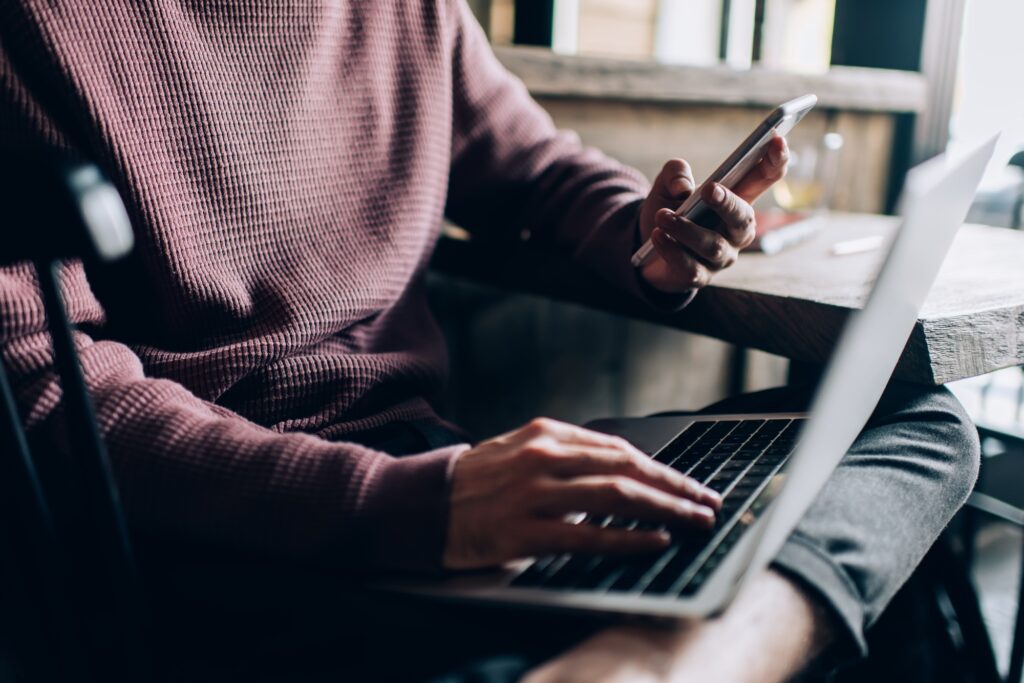Cropped view of skilled IT professional searching wireless page on digital devices