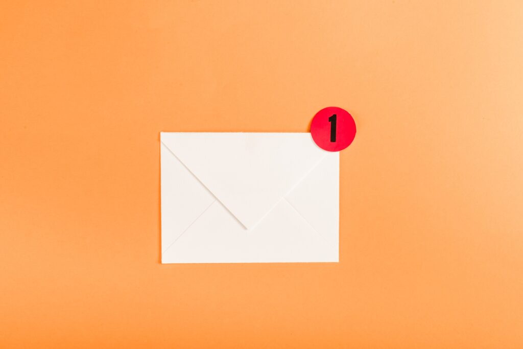 top view of paper envelope with red circle and notification with number 1 isolated on orange